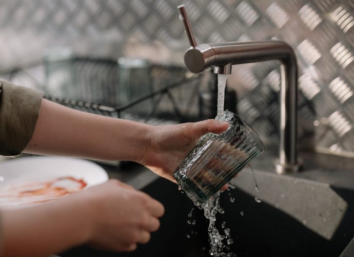 Personne qui fait la vaisselle avec une eau dure