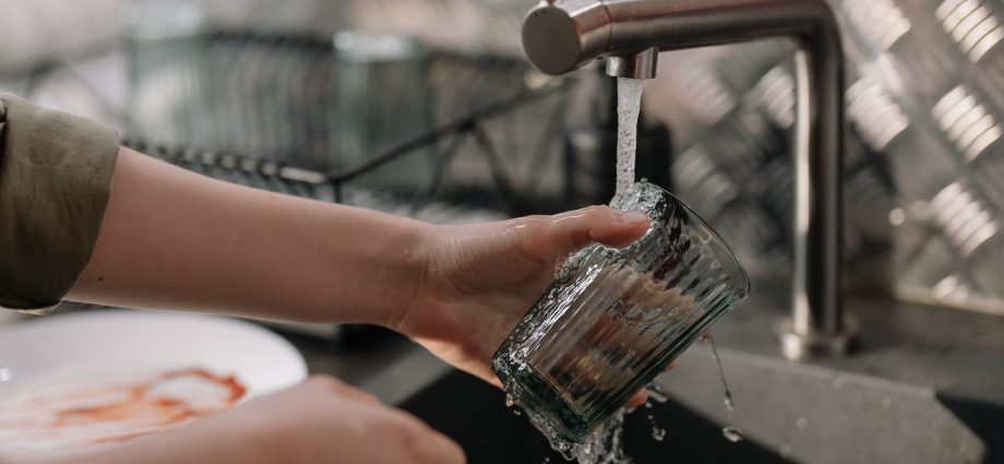 Personne qui fait la vaisselle avec une eau dure