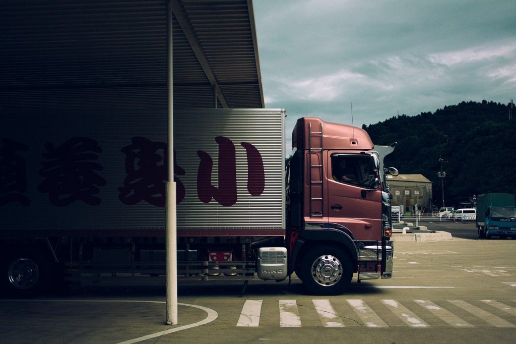 camion de transport quittant un entrepôt