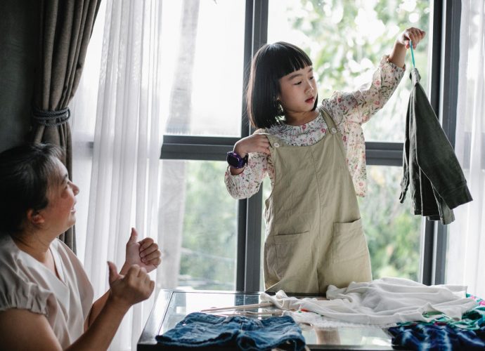 petite fille qui montre un vêtement à sa grand-mère